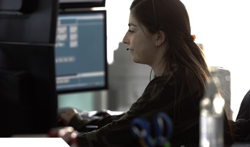 9-1-1 dispatcher on the computer, looking at screen and taking call